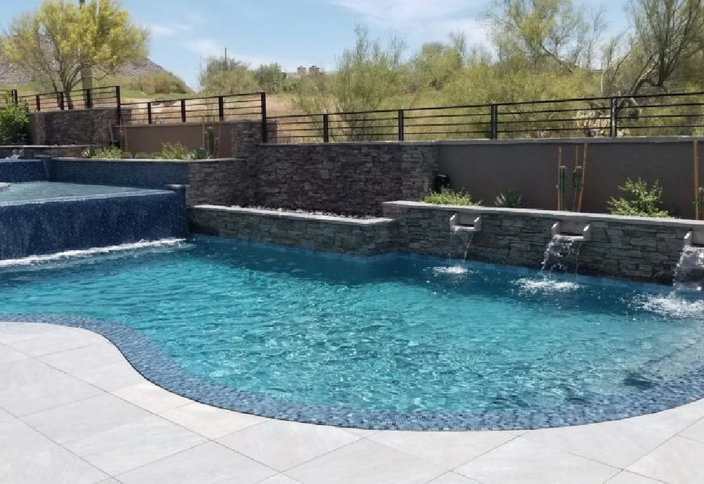 A pool with water jets and a wall.