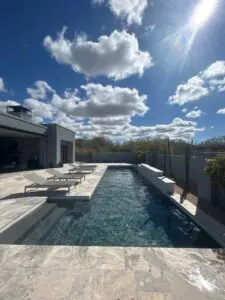 A pool with chairs and a bench in it