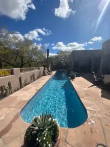 A pool with a view of the sky and trees.