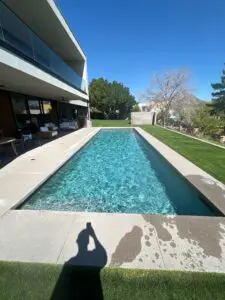 A long pool with a large swimming area in the middle of it.