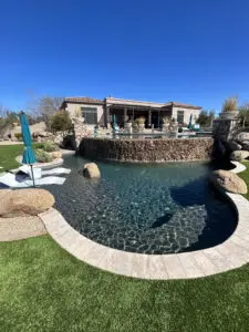 A pool with a waterfall and a rock wall.