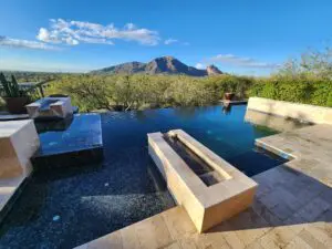 A pool with a view of mountains and trees.