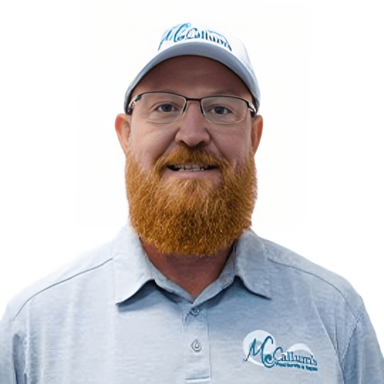 A man with a beard and glasses wearing a blue shirt