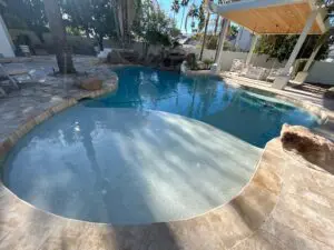 A pool with a clear surface and a white umbrella.