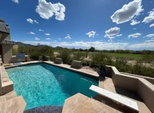 A pool with a view of the sky and grass.