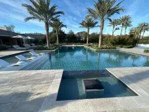 A pool with palm trees and a bench in the middle of it.